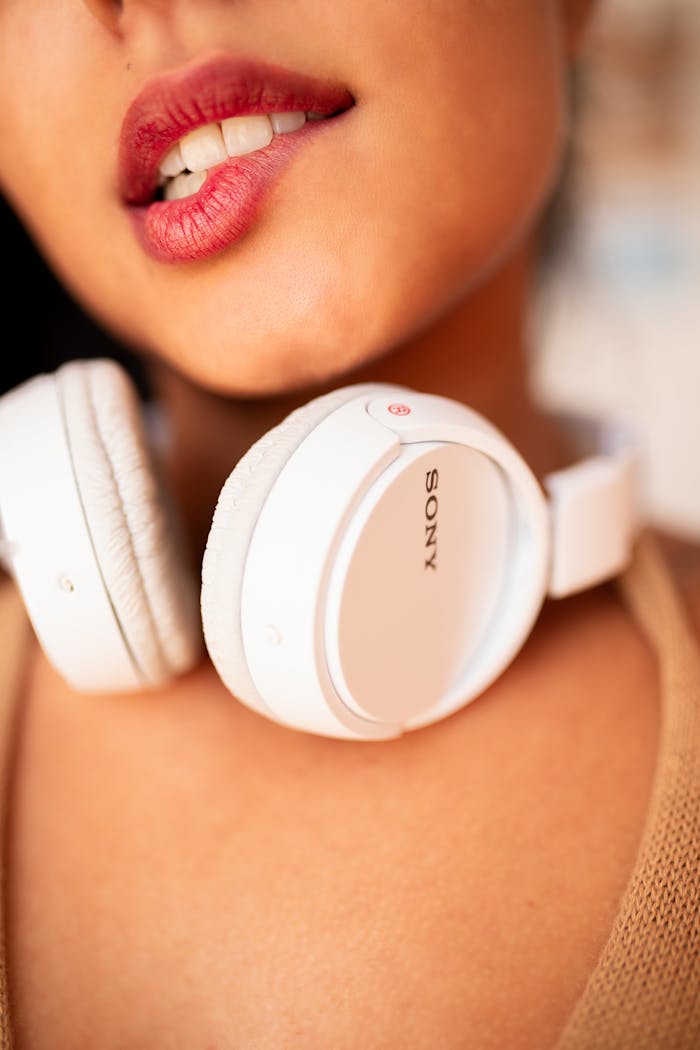 A close-up of lips biting while wearing white headphones, creating a stylish and modern look.